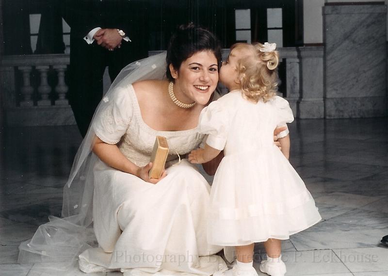 little girl whispering into brides ear.jpg